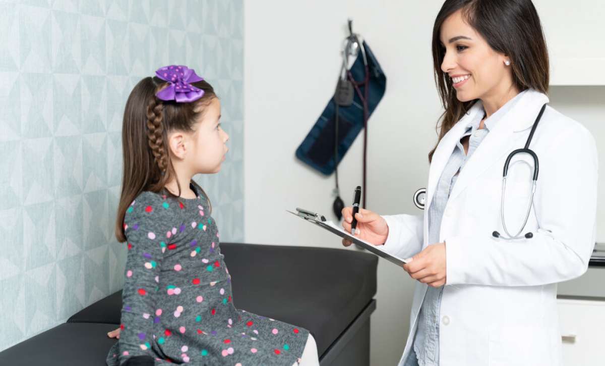 Family nurse practitioner examining young girl patient