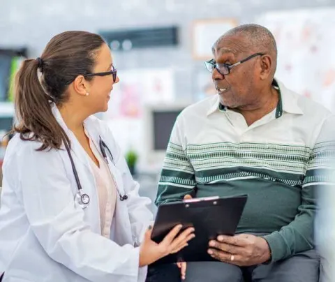 Adult-Gerontology Nurse Practitioner helping a senior in long term care