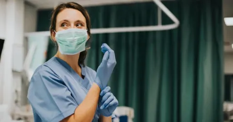 A nurse practitioner wearing her gloves