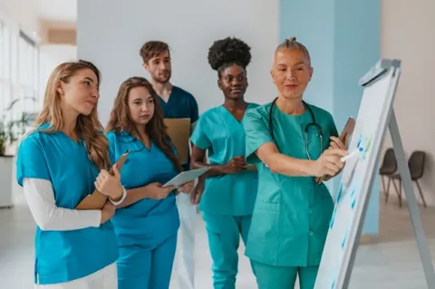 A nurse practitioner discusses some new patient care strategies with the nursing team.